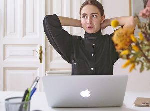 Woman leaning back in front of her computer